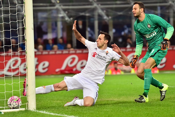Fiorentina's Croatian forward Nicola Kalinic (L) kicks to score flanked by Inter Milan's Slovenian goalkeeper Samir Handanovic during the Serie A football match between Inter Milan and Fiorentina at the San Siro Stadium in Milan on September 27, 2015 . AFP PHOTO / GIUSEPPE CACACE (Photo credit should read GIUSEPPE CACACE/AFP/Getty Images)